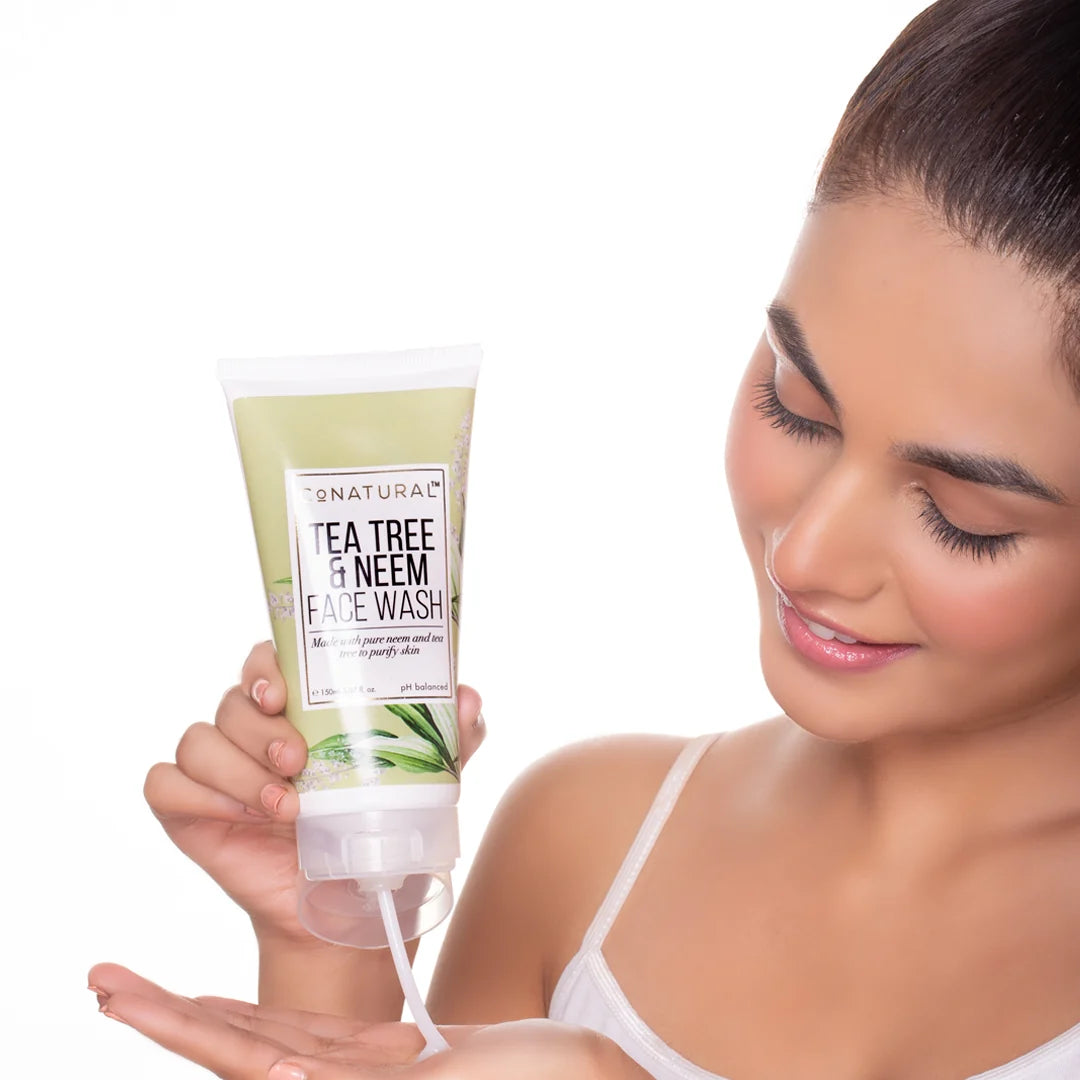 Tube of tea tree and neem face wash with green leaf design on a white background