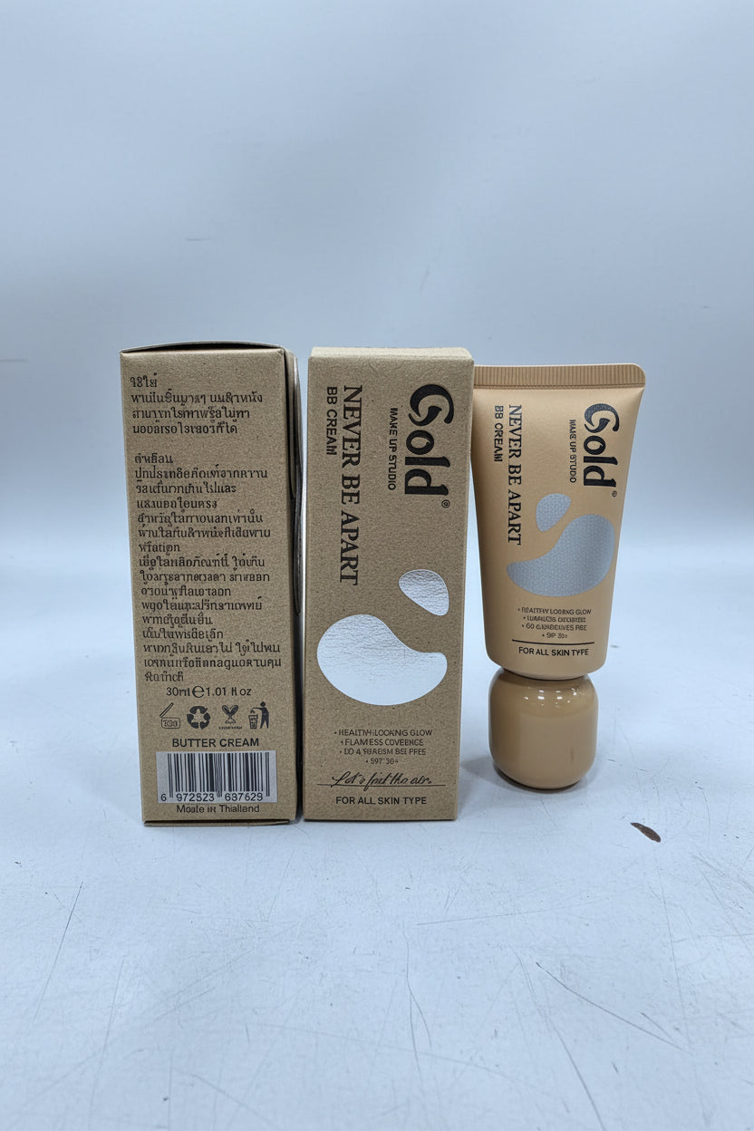 A tube of Gold Never Be Apart cream makeup with its cardboard packaging box, shown on a light gray background.
